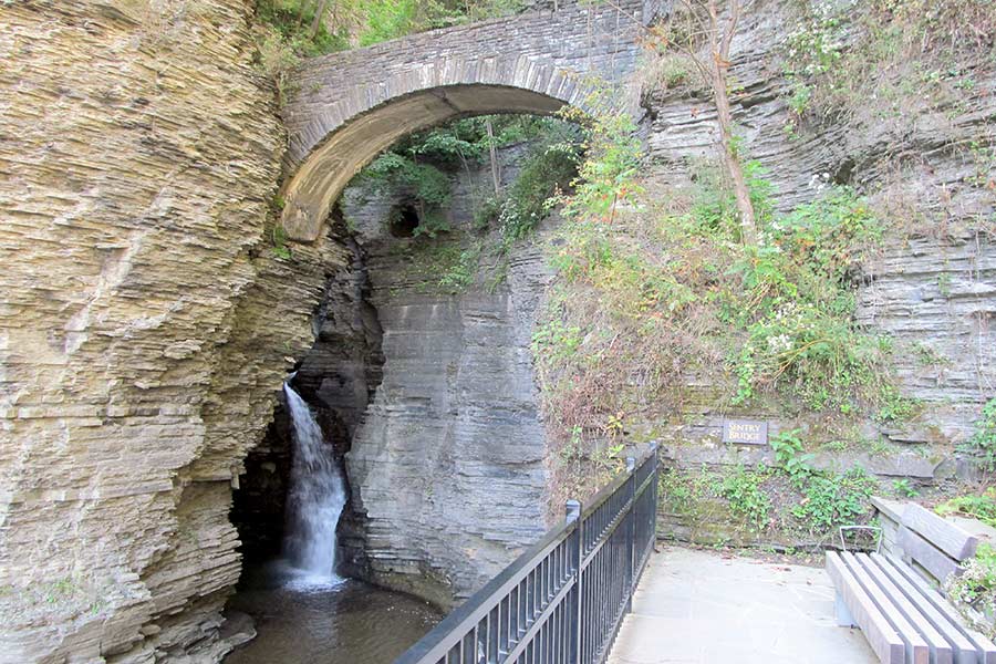 Arched stone bridge over small waterfall at Watkins Glen State Park