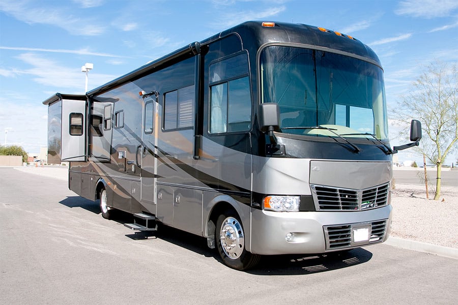Gray motorhome with black accents parked in parking lot