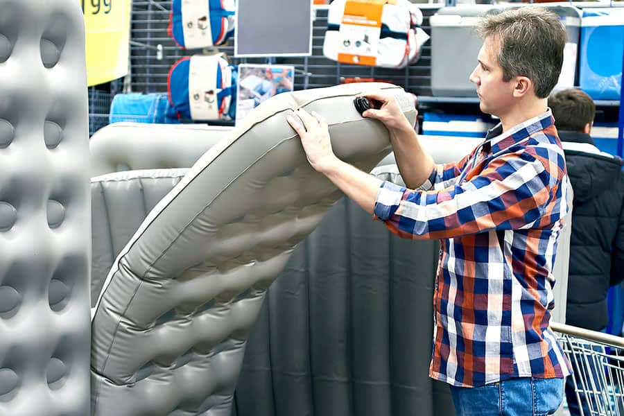 Man in store looking at an air mattress to buy