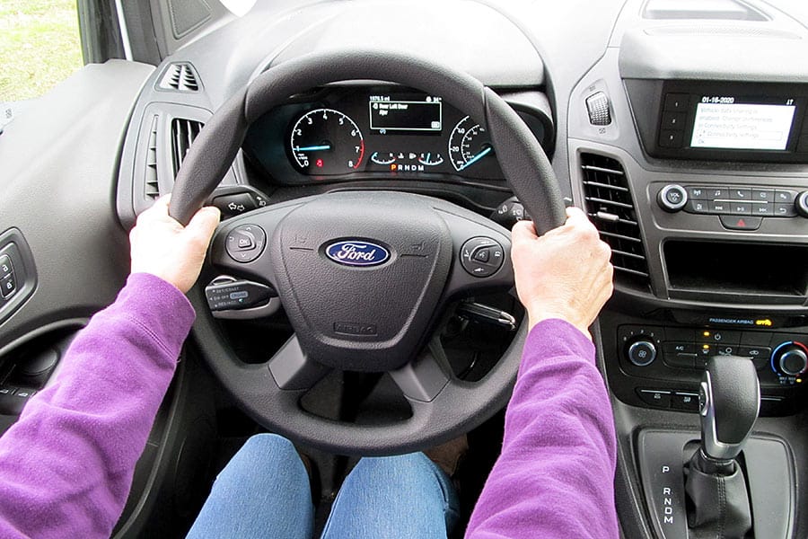 Woman with hands on steering wheel in a Ford van