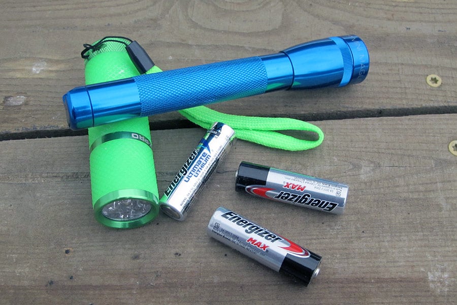 Two flashlights on table with batteries