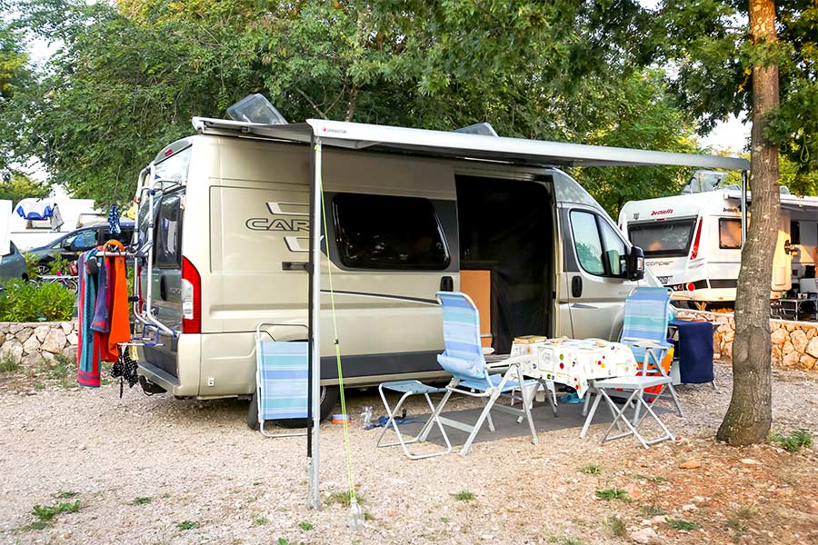 Camper van parked at campsite with awning extended