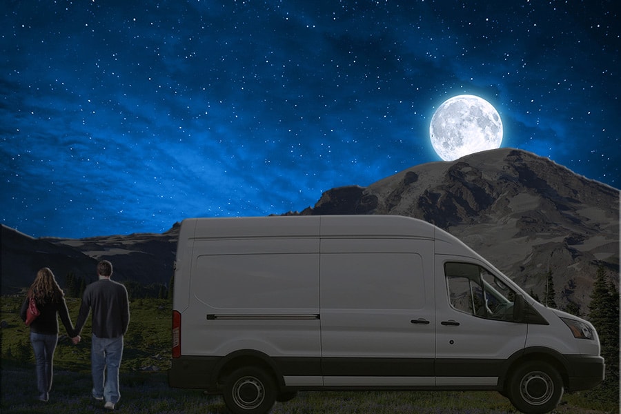 Light colored van parked at night with moon out