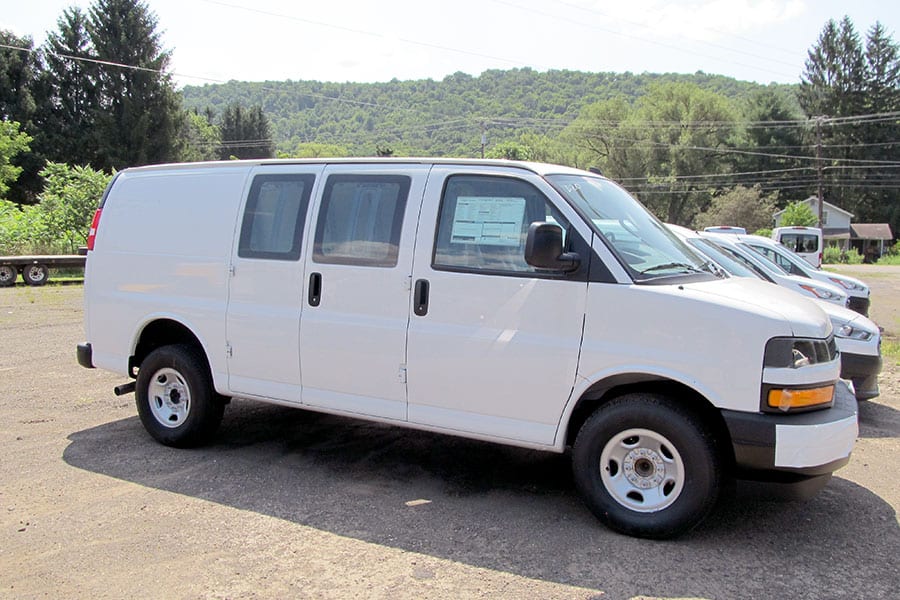 A white Chevy Express van on dealer lot