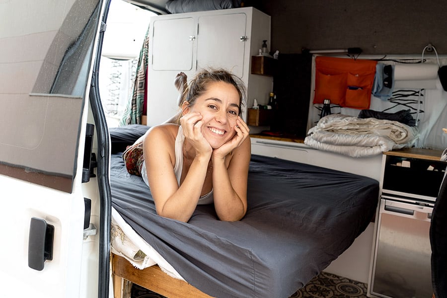 A woman laying on a bed in a van