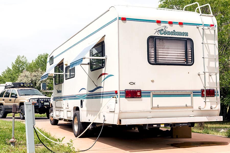 Class C RV connected to an electric pedestal at campground