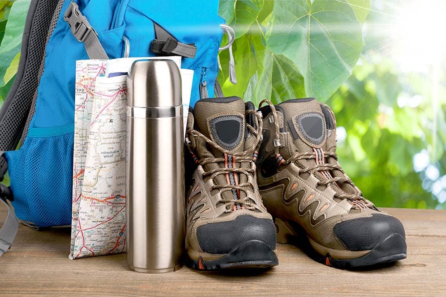 Blue backpack, map, thermos and hiking boots