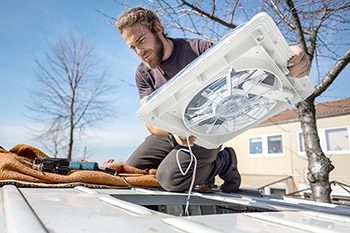 Man installing roof vent in van