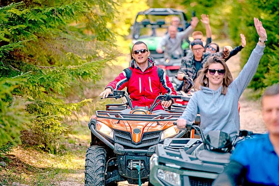 Group of ATV riders going through woods