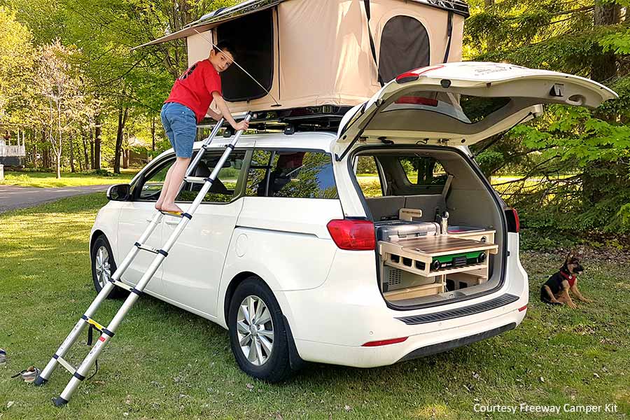 Boy climbing ladder to access a car's roof top tent
