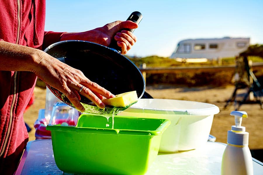 Woman washing dishes outside