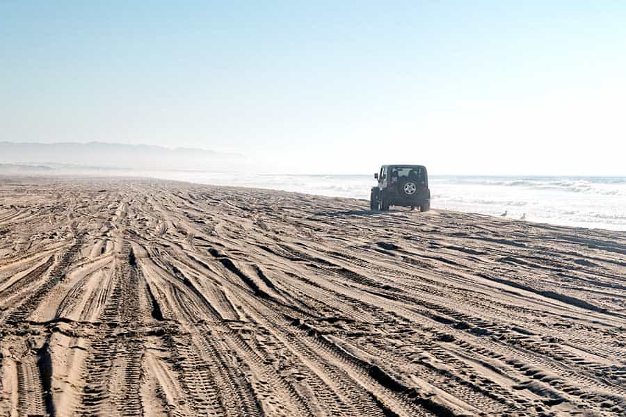 Jeep parked on the sandy beach at Pismo State Beach