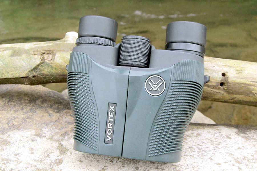 Vortex vanquish binoculars on rock leaning against stick