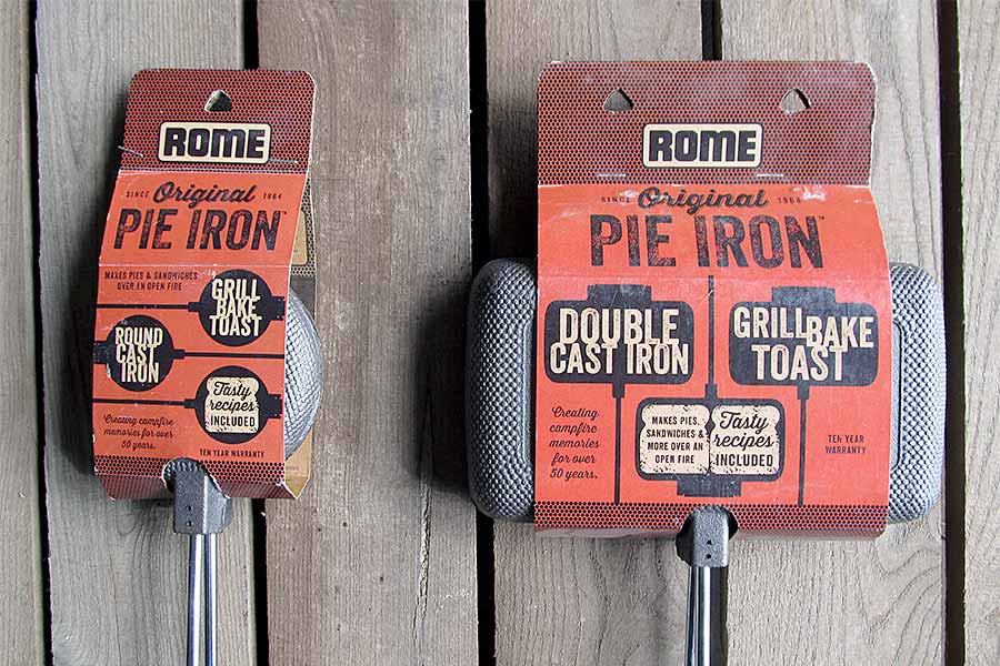 Two new pie irons laying on wooden picnic table