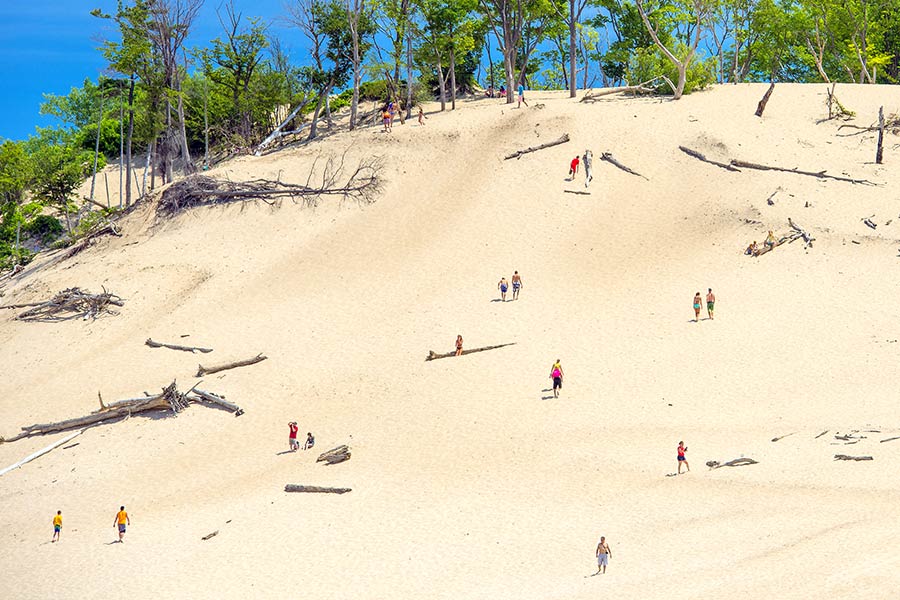 People walking up sand dune at Warren Dunes State Park, Michigan