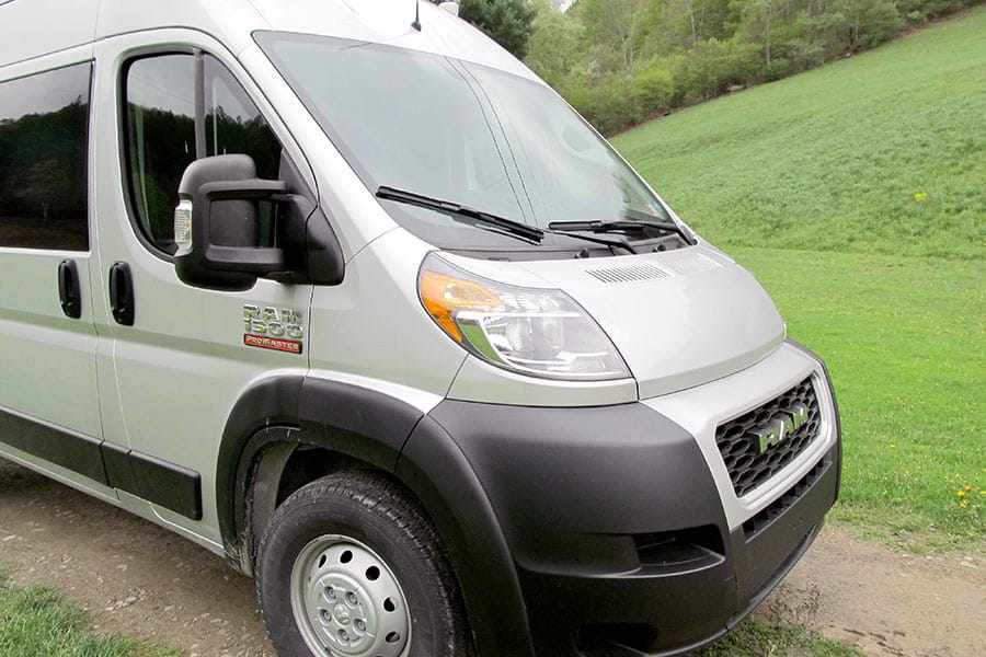 Front of a silver RAM Promaster with green grass in background