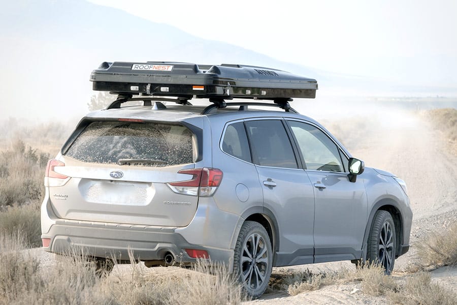 Silver vehicle with a closed rooftop tent on top
