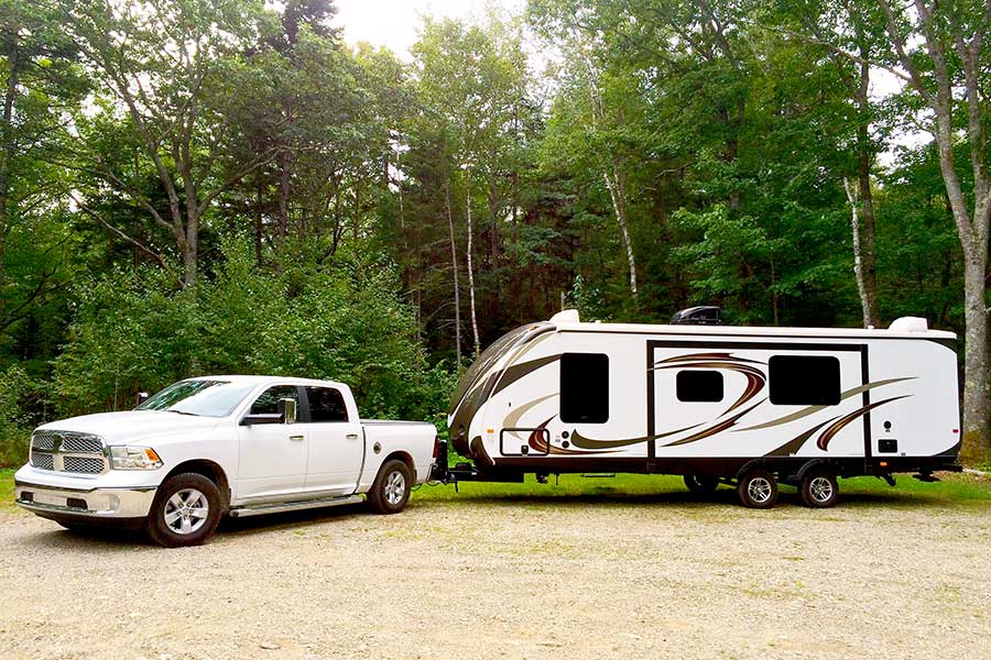 White Ram truck hooked to a camping trailer at state park