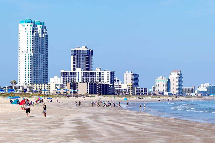 People on beach at South Padre Island, high-rises in background