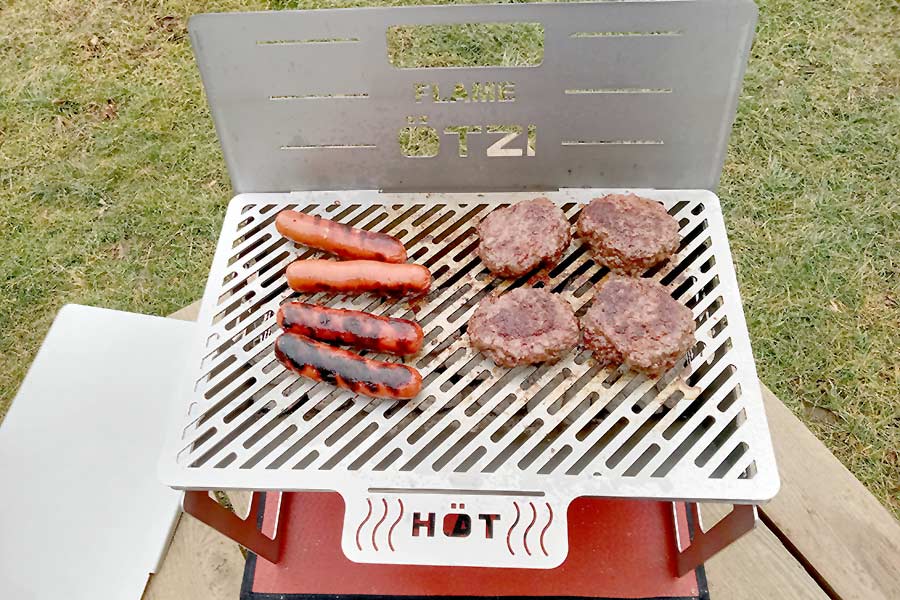 Hotdogs and hamburgers cooking on grill